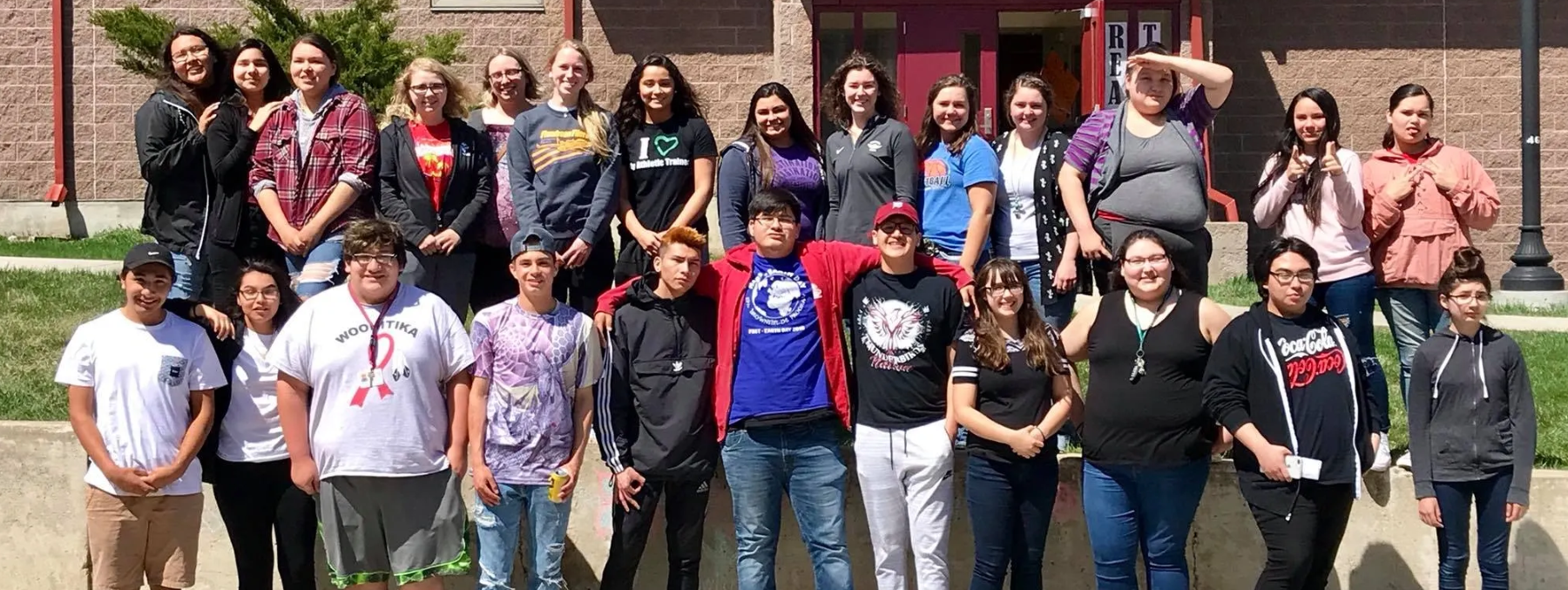 Large group of students standing together outside.