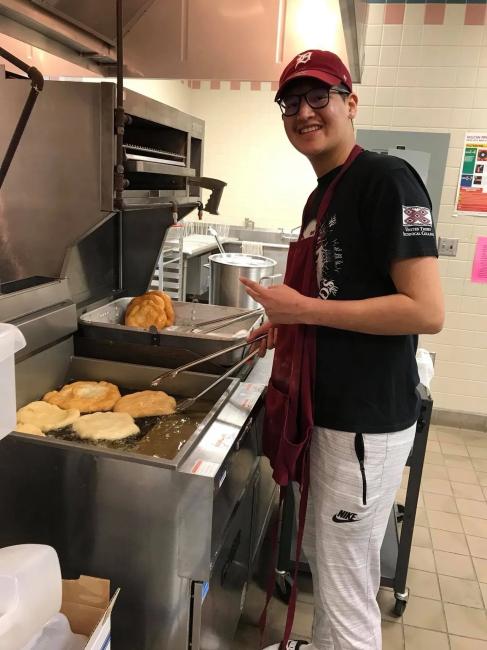Student cooking food in the kitchen.